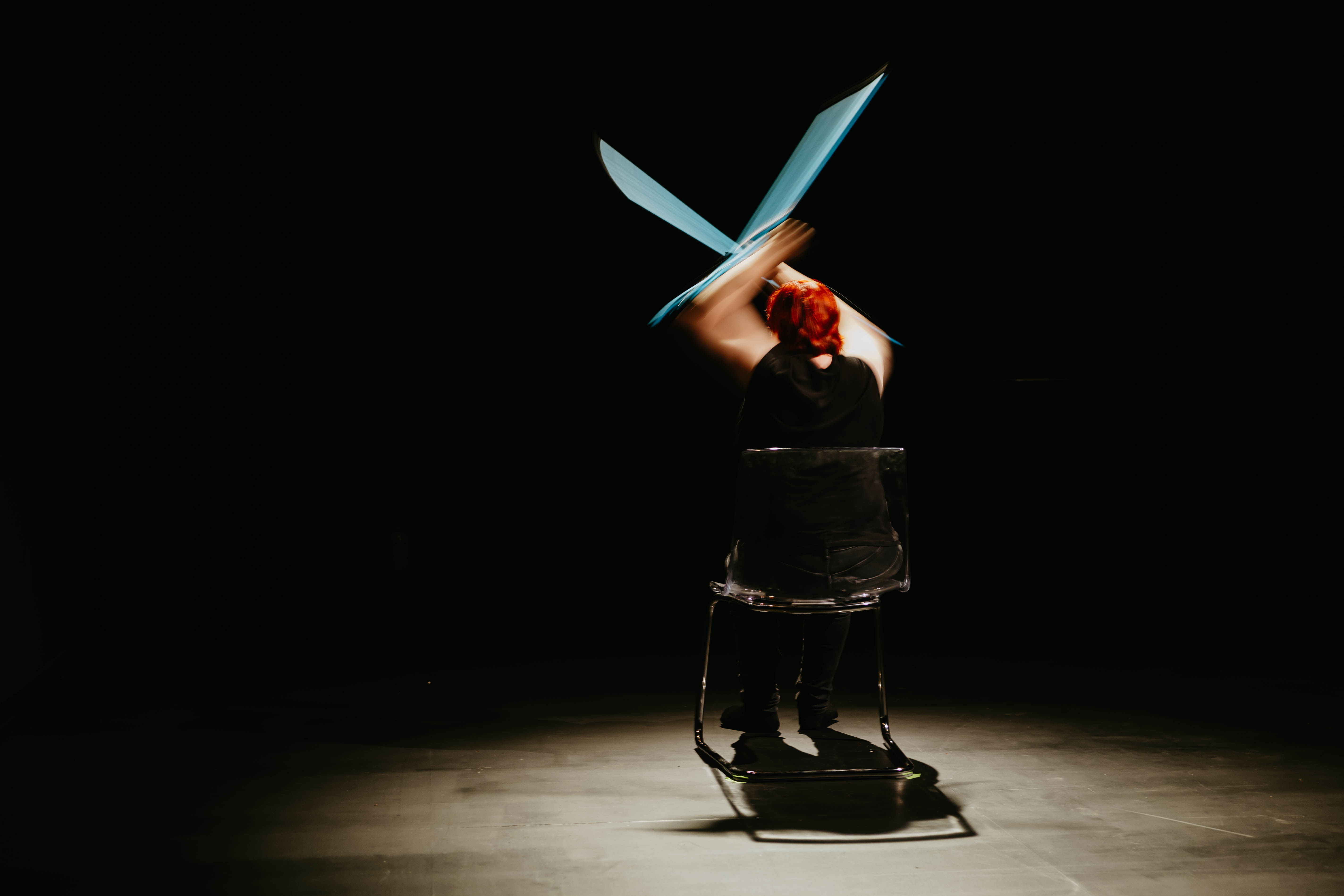 Η Ντέμη κάθεται σε μια καρέκλα με την πλάτη της σε εμάς και σηκώνει πάνω απο το κεφάλι της τις μπλε πατερίτσες της