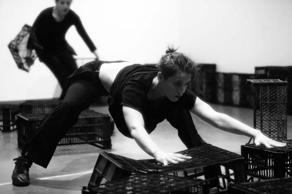 two dancers are moving crates rapidly
