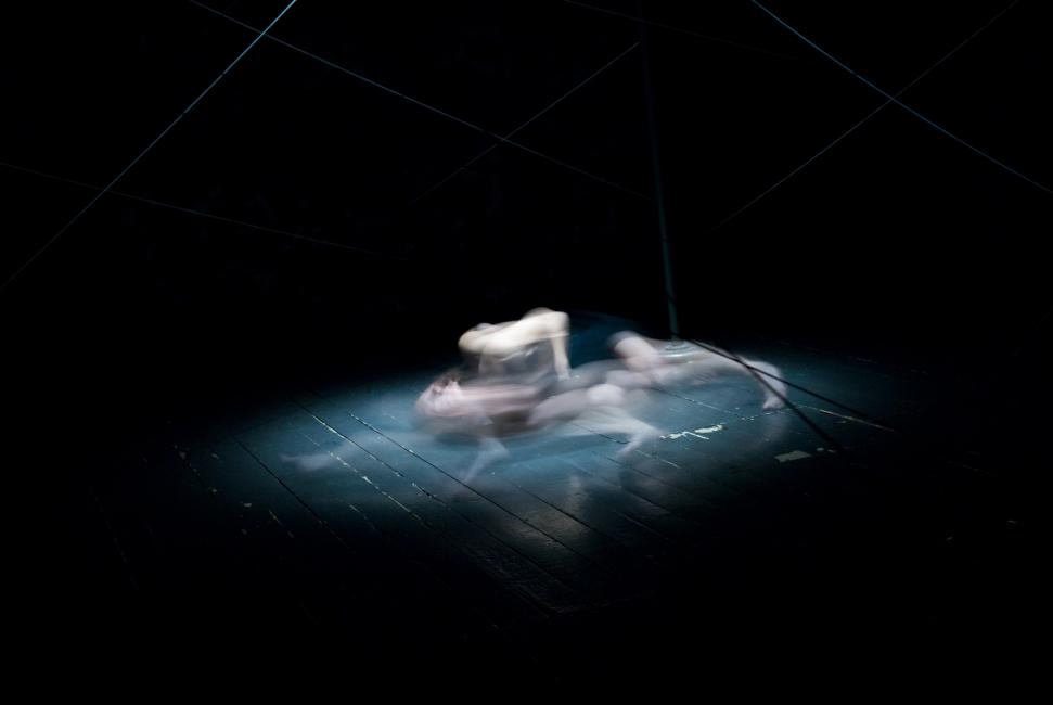 a performer is seen vaguely as she is captured turning on the floor
