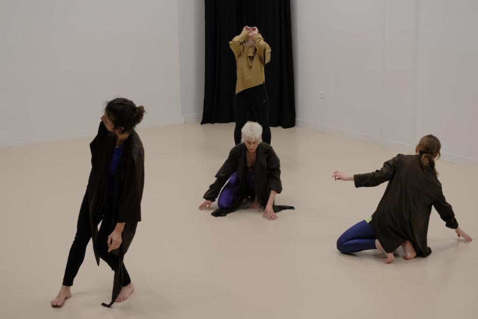 Against a stark black and warm beige backdrop, the quartet forms a landscape of shifting bodies